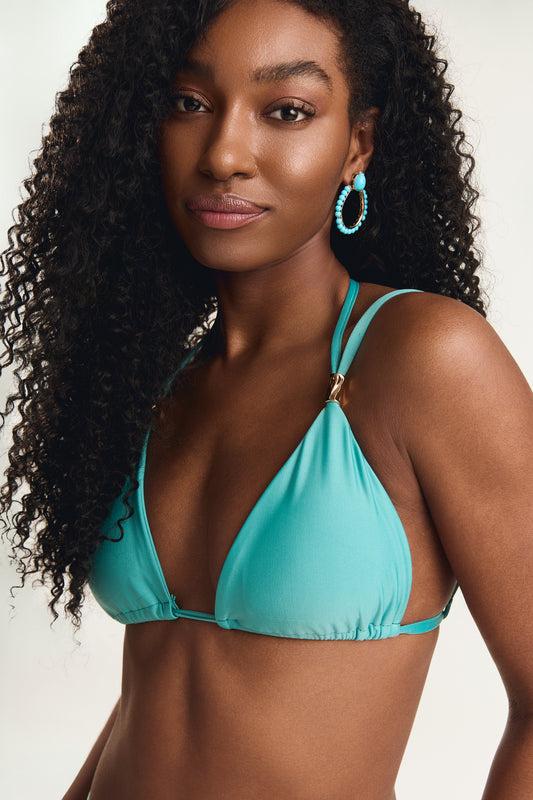 Top metal canudo na cor Jade, close no busto com modelo em posição frontal levemente inclinada, detalhe do acabamento triangular e alças duplas com metal canudo dourado