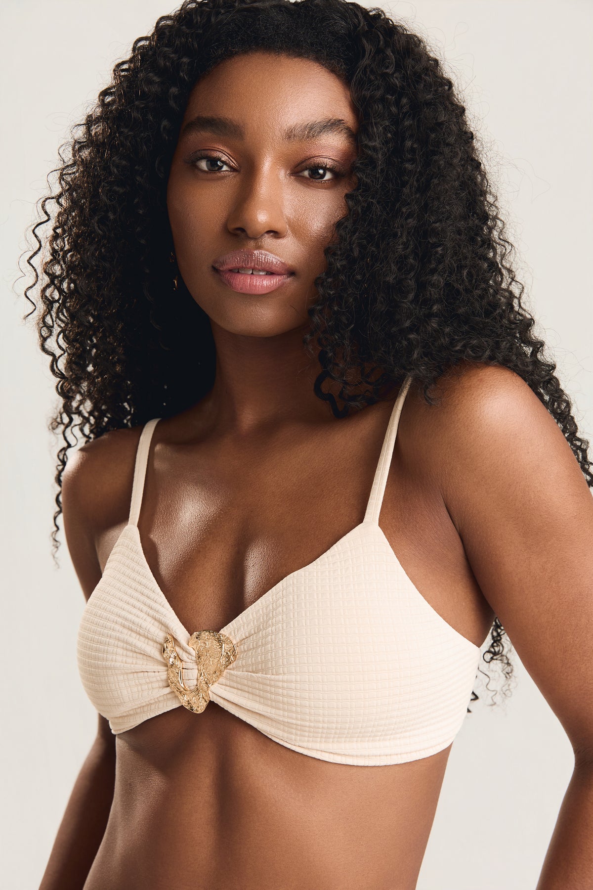 top metal amassado na cor off white textura com metal dourado central — modelo posada de frente, enquadramento close no busto, olhando para a câmera