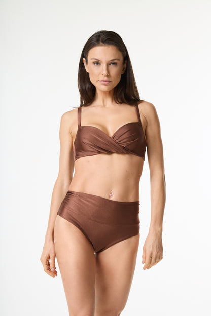 Biquíni top drapeado cintura alta bronze. A modelo está de pé em fundo branco, de frente para a câmera, mostrando o caimento do top e da calça de cintura alta."