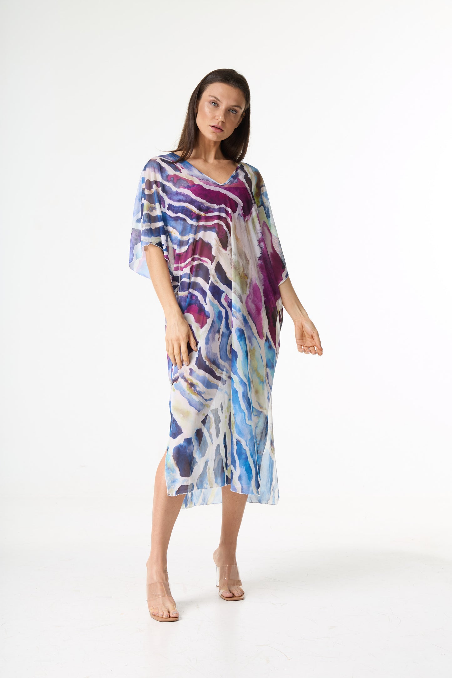 Saída de praia kaftan com estampa abstrata em pinceladas de azul, roxo e branco. A modelo posa de frente em estúdio, exibindo o caimento solto da peça.
