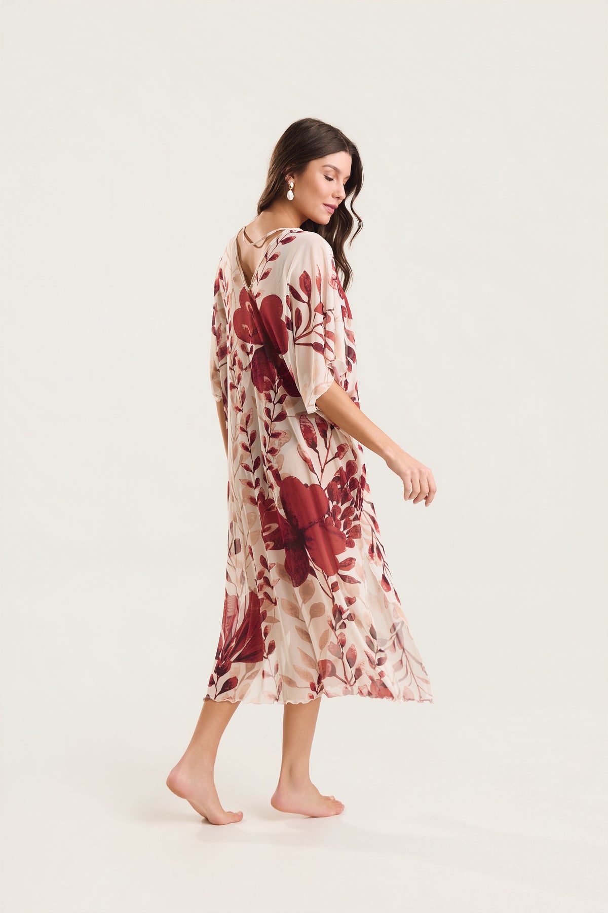 Kaftan Tule Mareblu em tule floral com estampa de flores e folhagens — modelo de costas em ¾, em movimento, destacando a fluidez e o caimento da peça