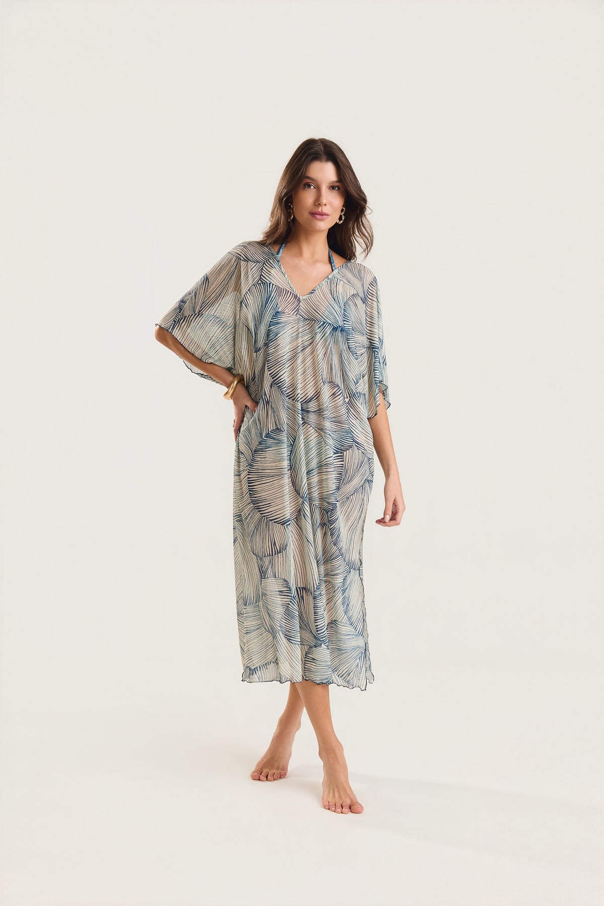 Kaftan Tule Mareblu em tule com estampa concha azul — modelo de frente em postura elegante, braço levemente afastado do corpo, destacando o comprimento midi e as mangas amplas
