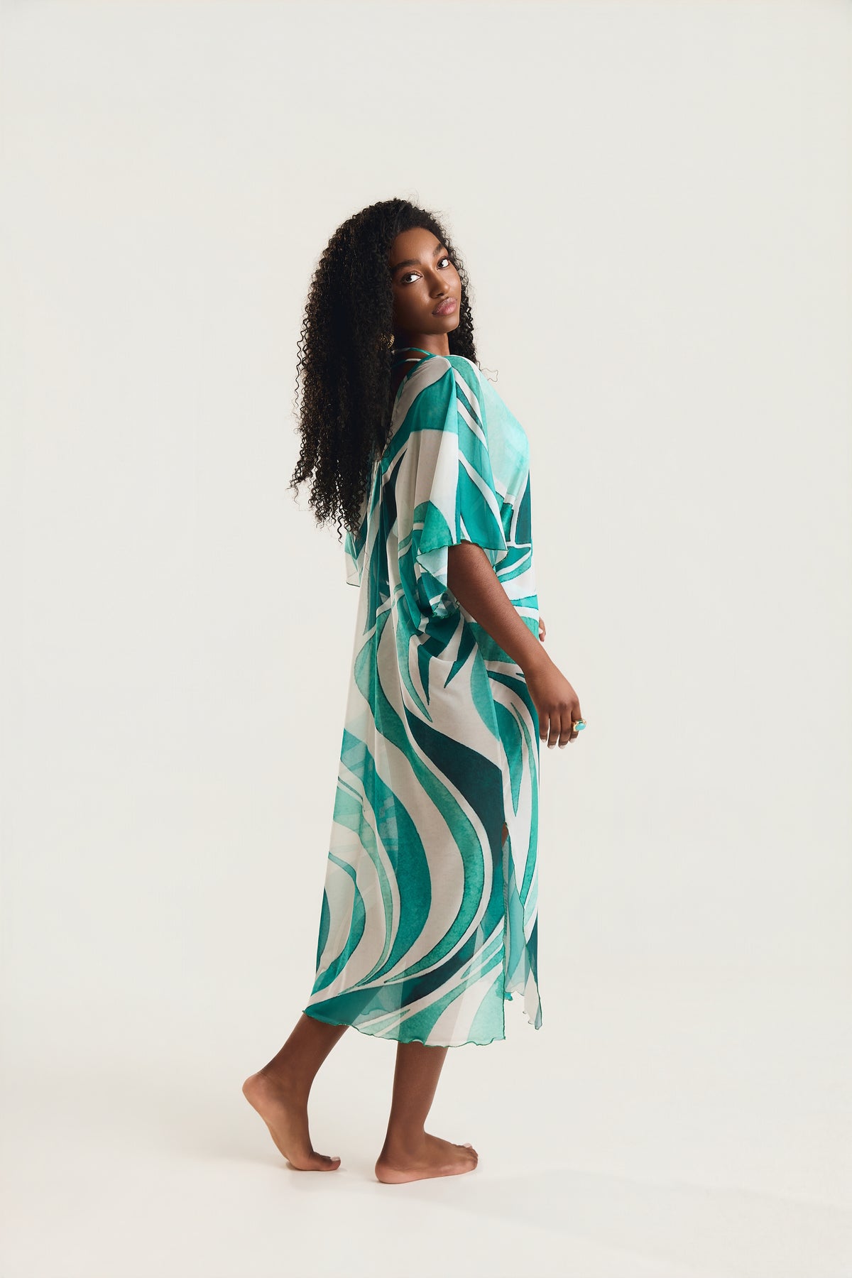 Kaftan Tule Mareblu em tule com estampa geométrica verde — modelo de perfil em movimento, destacando o caimento fluido e as mangas amplas