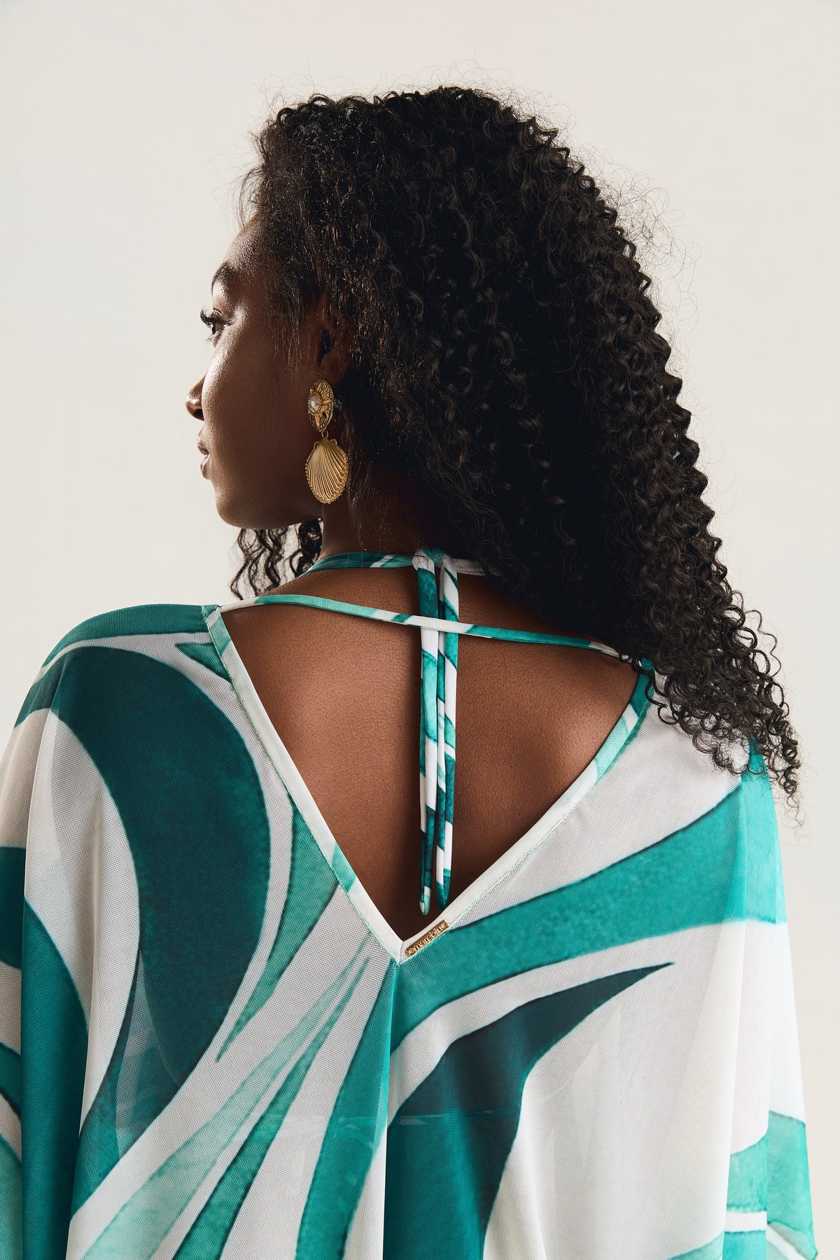 Kaftan Tule Mareblu em tule com estampa geométrica verde — detalhe do decote V profundo nas costas, evidenciando o acabamento refinado da peça