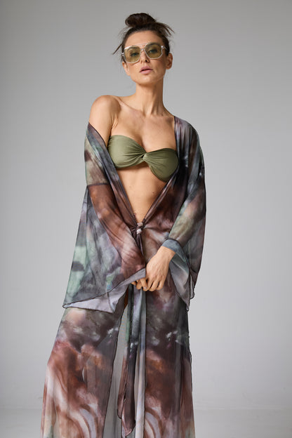 Saída de praia quimono estampado tie-dye com biquíni tomara que caia verde-oliva. A modelo veste a peça aberta amarrada na cintura,