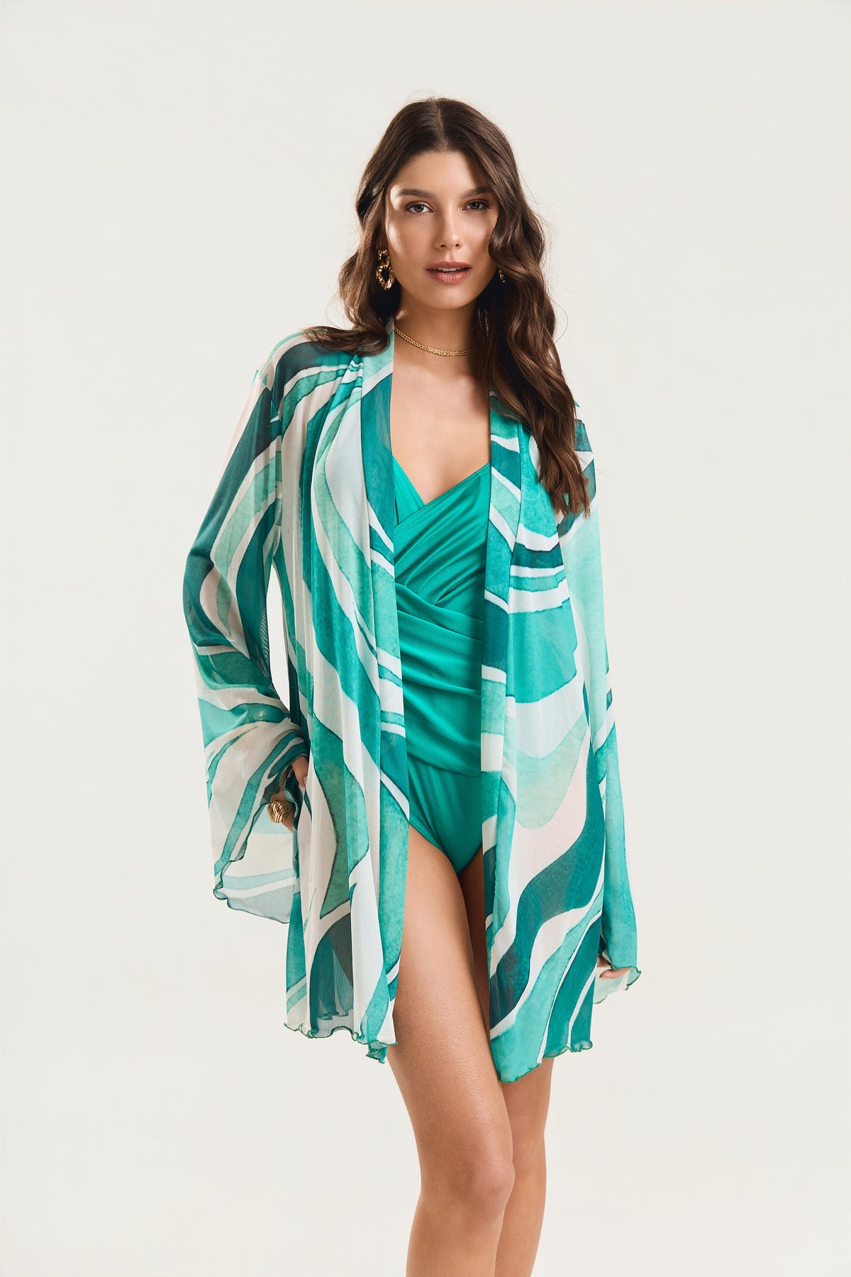 Kimono de manga longa com estampa geo verde, modelo em posição frontal levemente de lado olhando para a câmera
