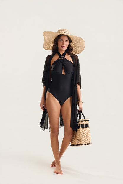Modelo em posição frontal caminhando, usando maiô preto com decote halter e argola dourada
