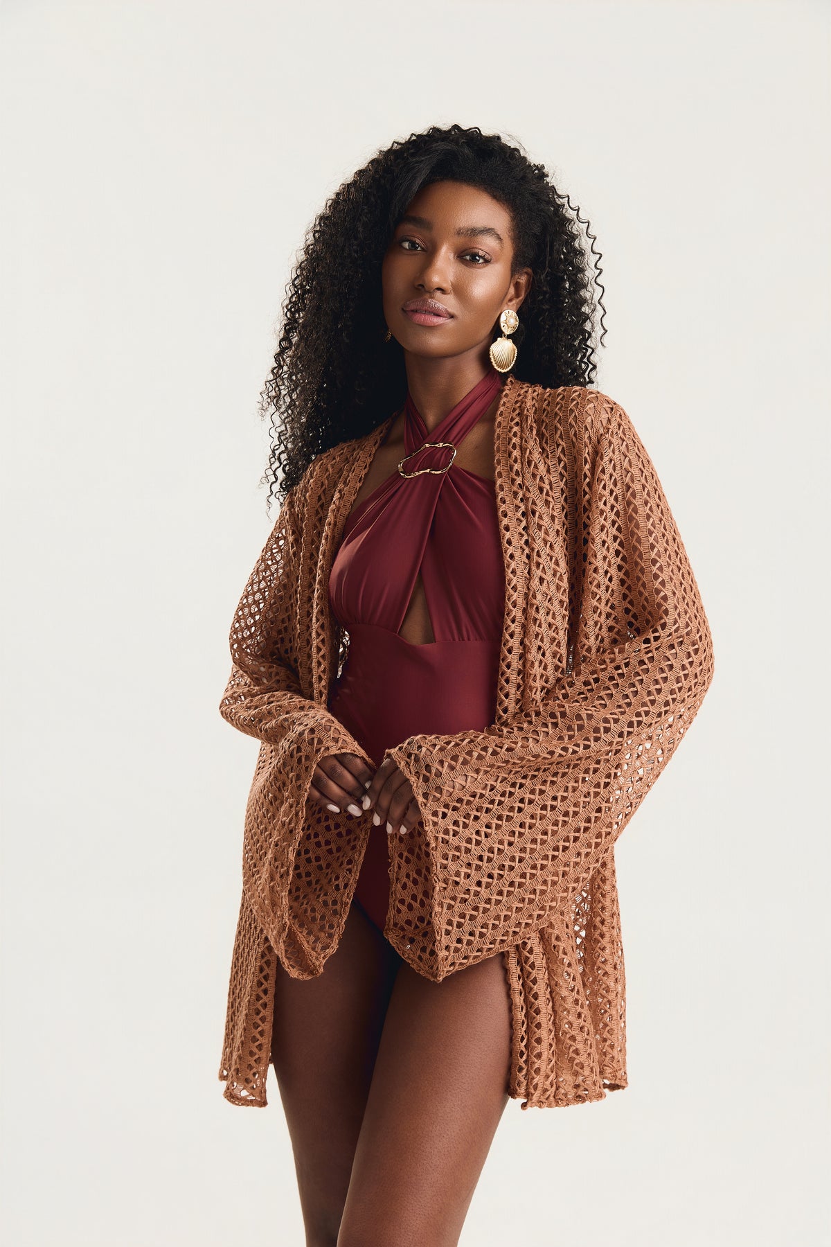 Kimono de manga longa em crochê, modelo em posição frontal levemente de lado olhando para a câmera