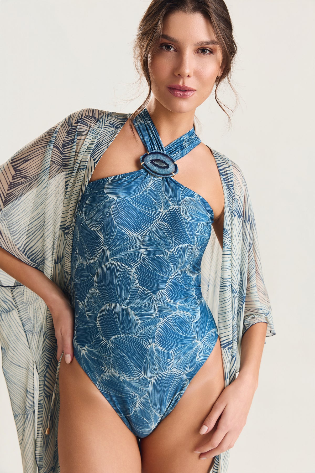 Maiô Pedra Pescoço estampa Conchas Azul, modelo posando de frente com saída de praia kimono, olhando para a câmera