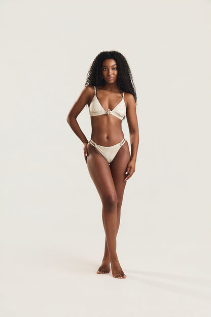 Top metal coral e calcinha roletê duplo conchas off white, modelo em posição frontal com corpo inteiro visível e mão na cintura
