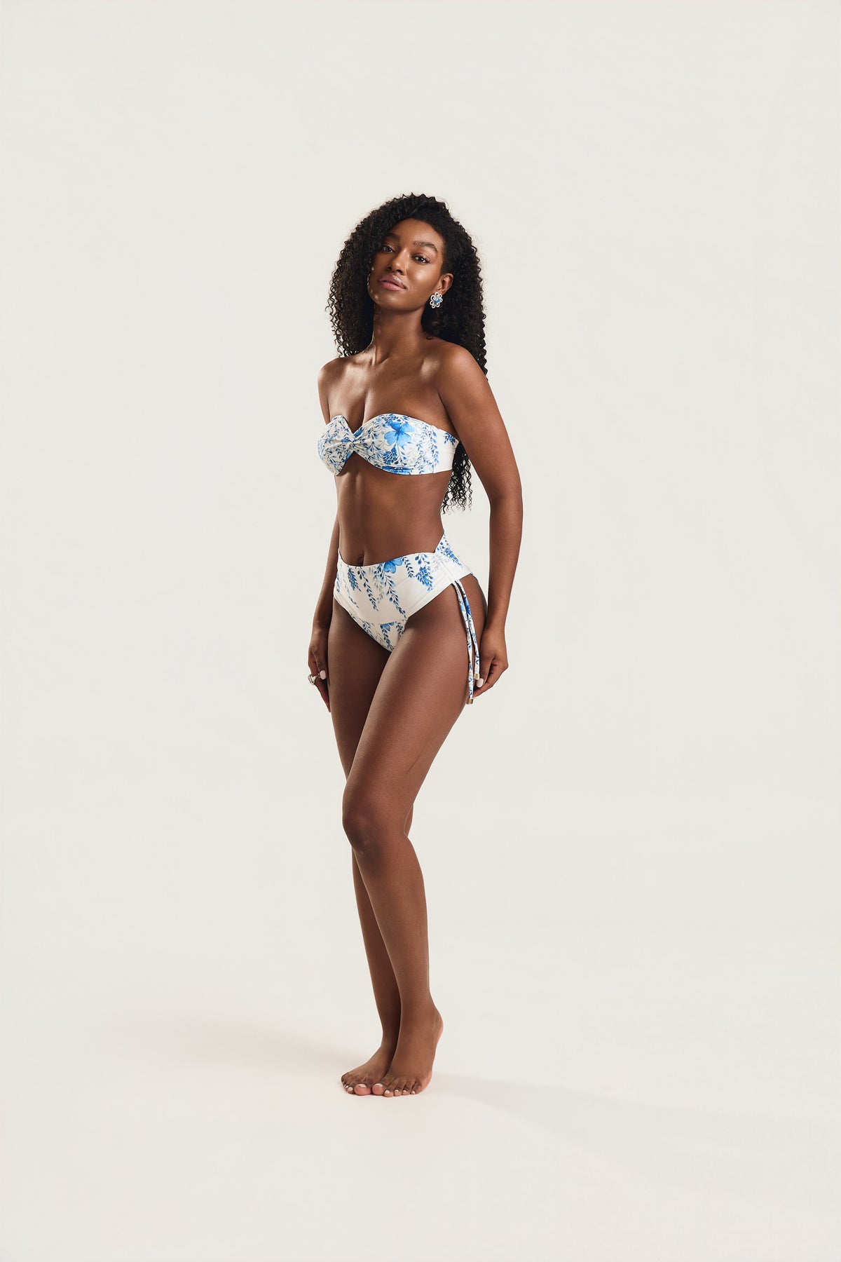 Modelo em pé de corpo inteiro usando biquíni top tomara que caia e calcinha cintura alta de amarrar lateral
