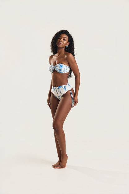Modelo em pé de corpo inteiro usando biquíni top tomara que caia e calcinha cintura alta de amarrar lateral
