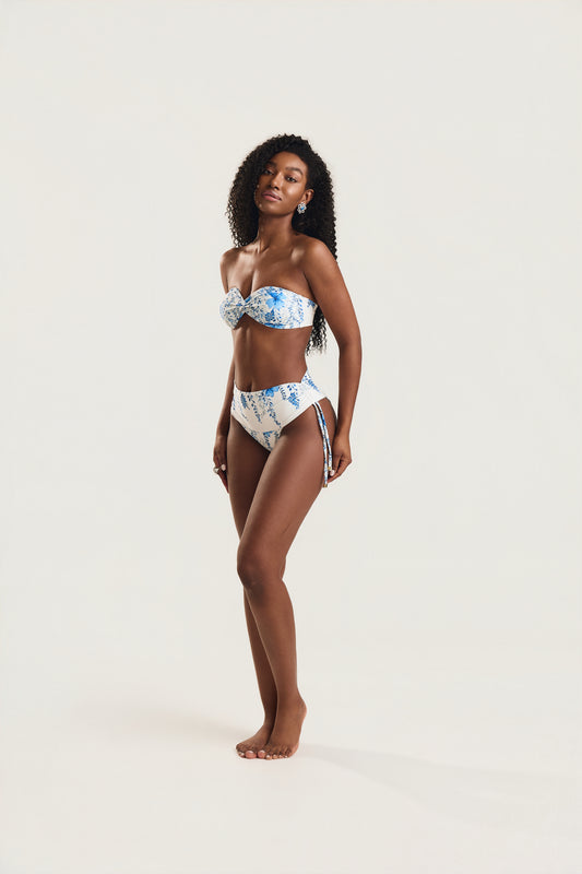 Modelo em pé de corpo inteiro usando biquíni top tomara que caia e calcinha cintura alta de amarrar lateral
