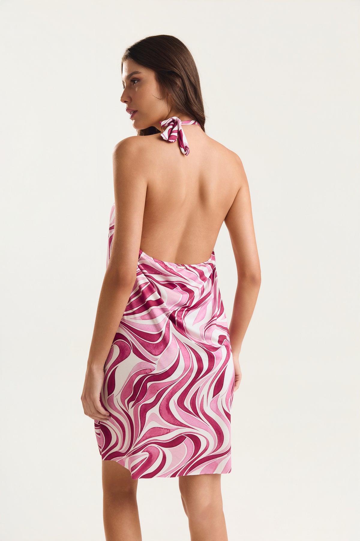 Vestido frente única com estampa geo rosa, modelo de costas mostrando o decote 