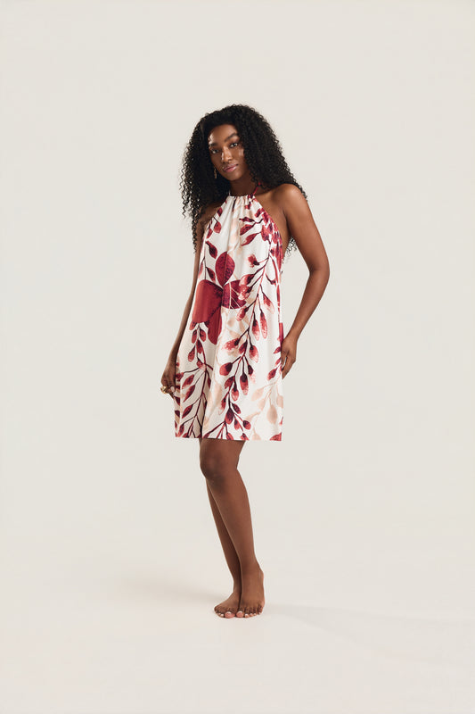 Vestido frente única com estampa foral vermelho e decote nas costas, modelo de frente levemente inclinada para o lado