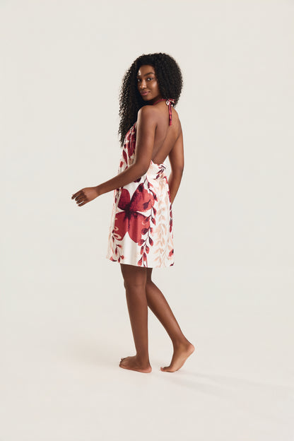 Vestido frente única com estampa foral vermelho e decote nas costas, modelo de lado mostrando decote nas costas 
