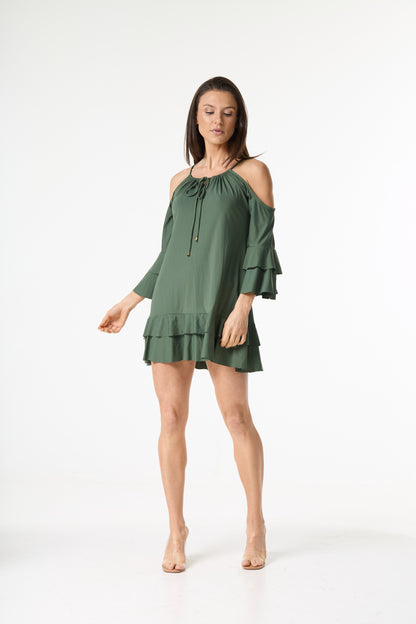 Vestido verde-oliva com decote ombro a ombro e mangas e barra com babados. Modelo em pé, de corpo inteiro, olhando para baixo, em fundo branco.